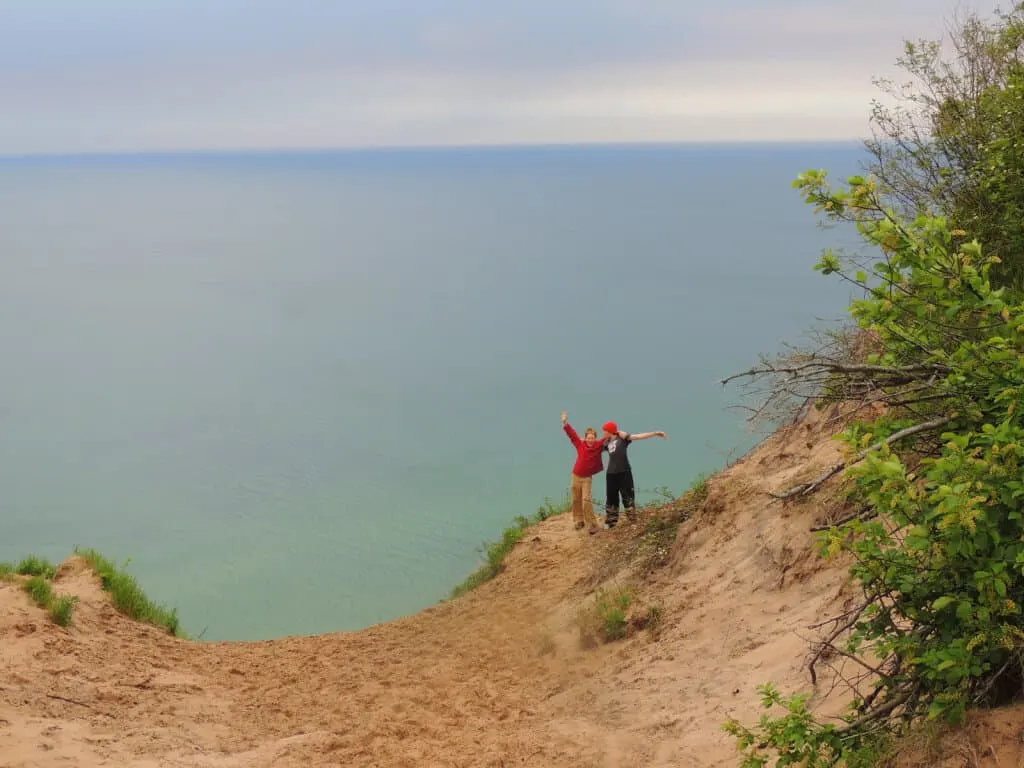 Two boys stand on the edge of a sand dune on the shores of Lake Superior during a family lake vacation.