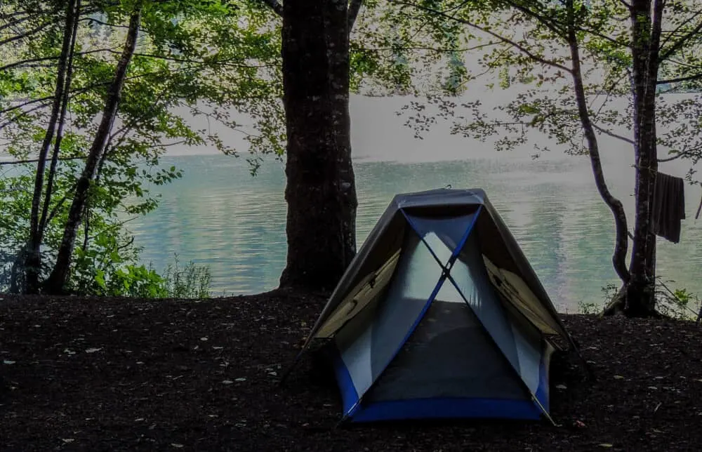 a small tent on the edge of a bright blue lake in North Cascades National Park