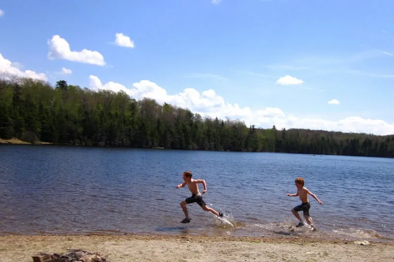 Two boys running through the water near the beach at Woodford State Park