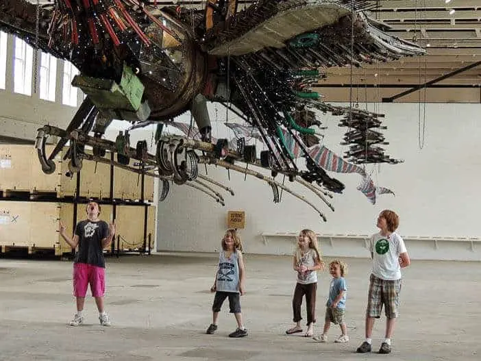 Several kids stand under a giant art installation at MASS MoCA in the Berkshires.