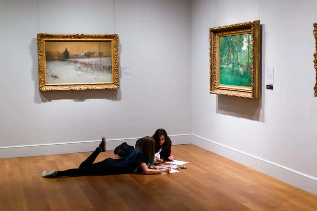 Two teenagers relax on the floor of one of the galleries at The Clark in Williamstown, Massachusetts.