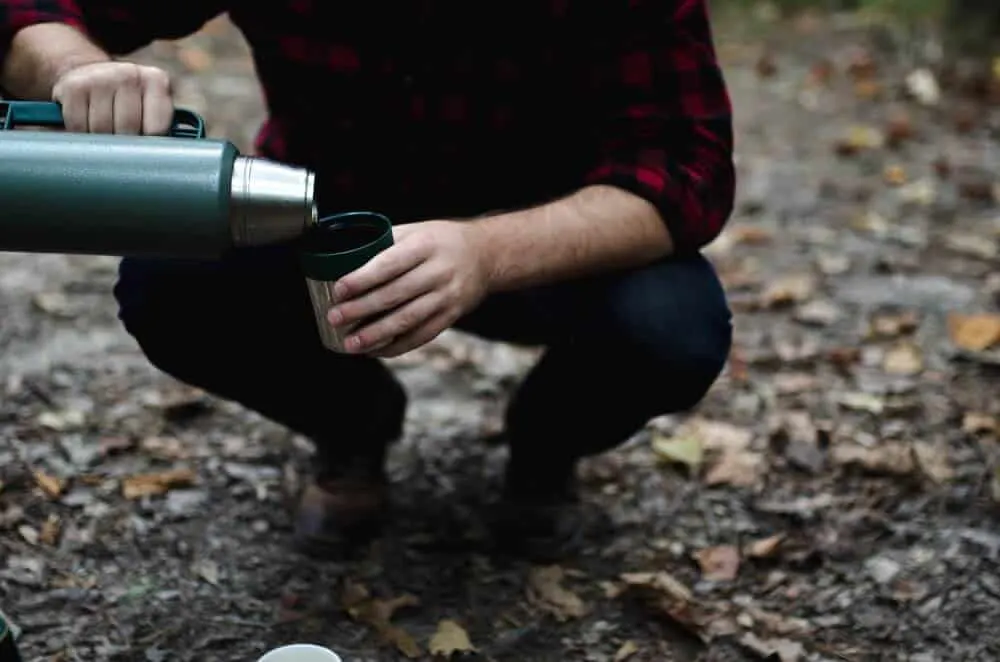 Premium Photo  Pouring hot drink out of thermos at a campsite