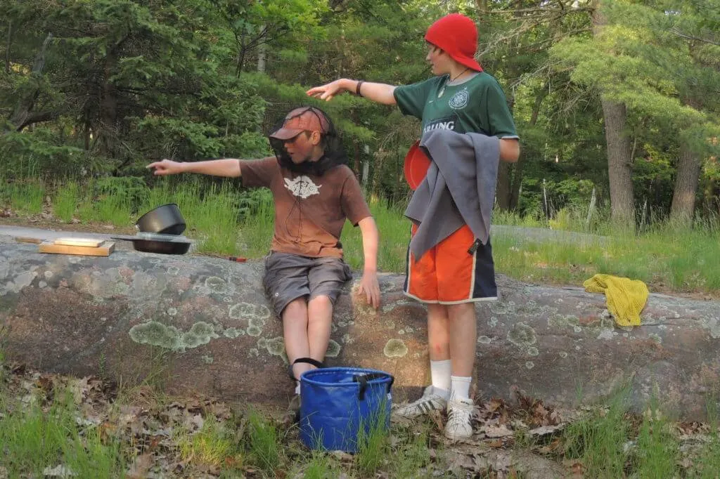 How to wash dishes while camping? Make your kids do it! Our kids when they were younger washing the camping dishes in the woods.