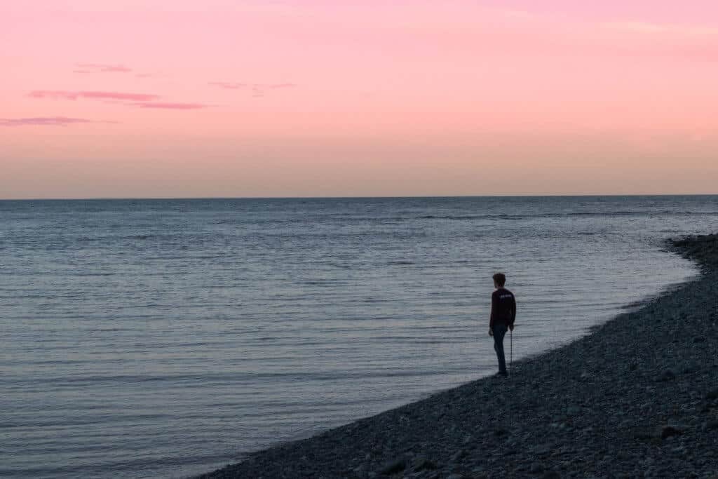 Fundy National Park camping A boy stands on the edge of the Bay of Fundy watching the tides go out.