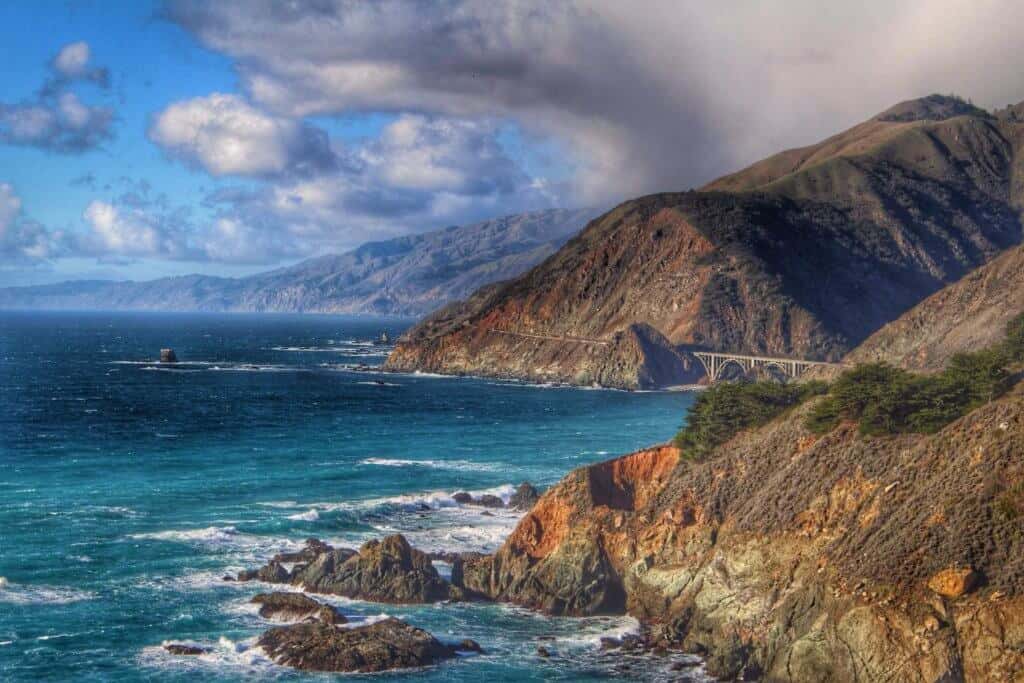 The rocky coastline of Big Sur with turquoise waters and cloudy skies