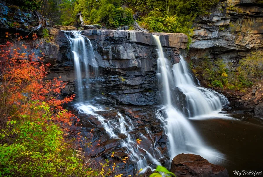a beautiful waterfall surrounded by fall colors in West Virginia