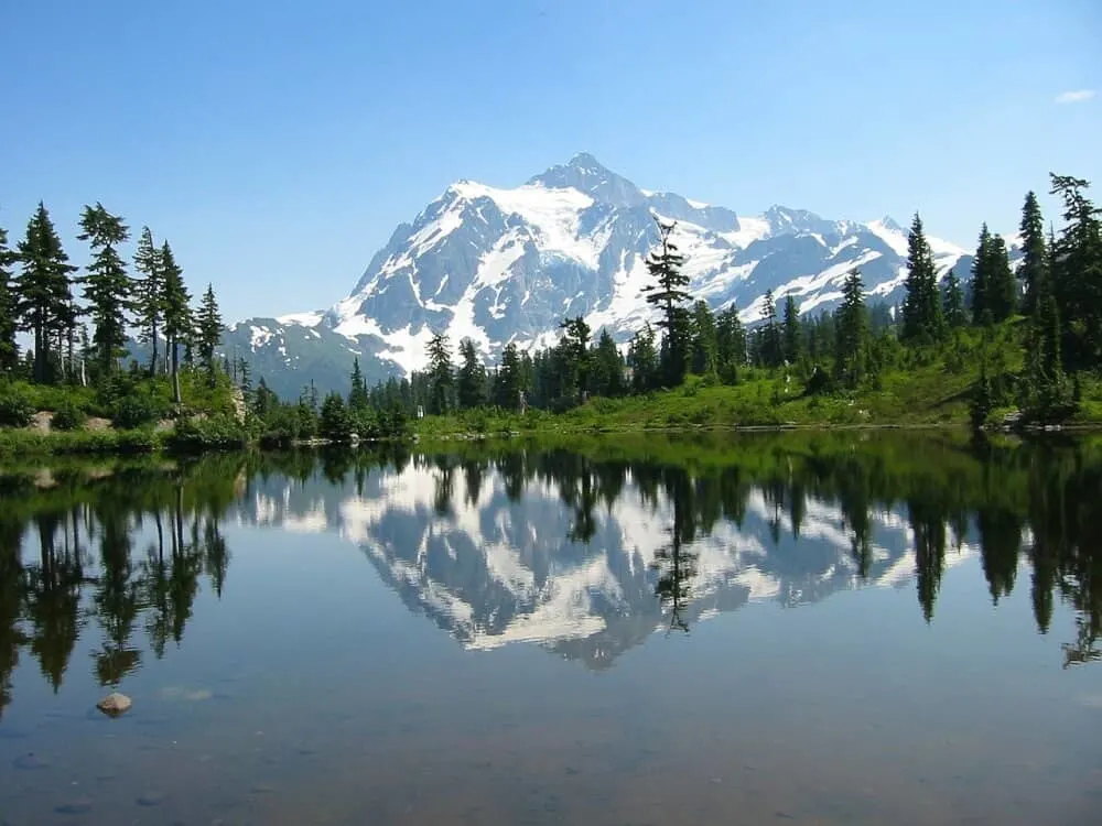 a snow-capped mountain reflected in a lake in North Cascades National Park