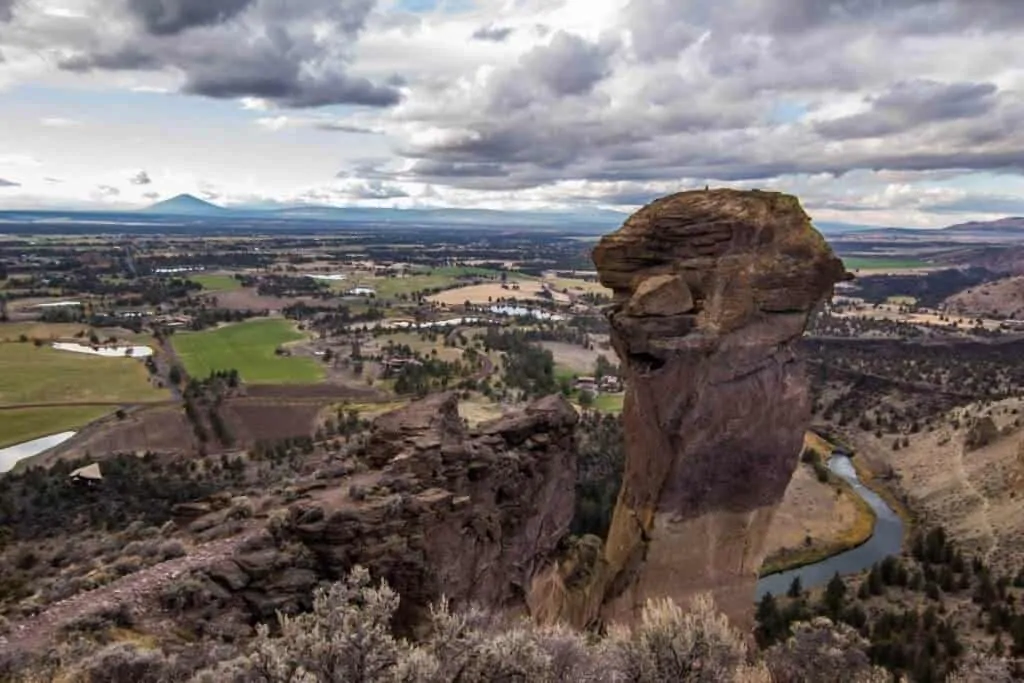a sweeping vista of a large rock formation and the valley below - Smith Rock State Park