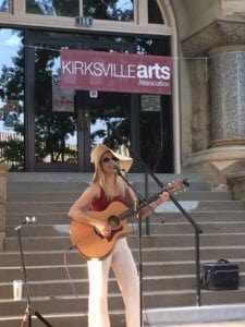 A woman plays a guitar at the summer concert series in Kirksville, Missouri