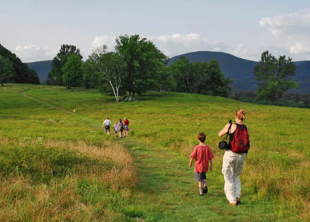 A family hikes through the meadow at the Clark Art Institute in Willamstown, MA