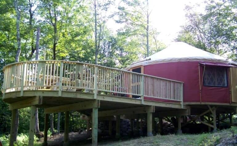 A red yurt with a sprawling deck outside - located in Livingston Manor, New York