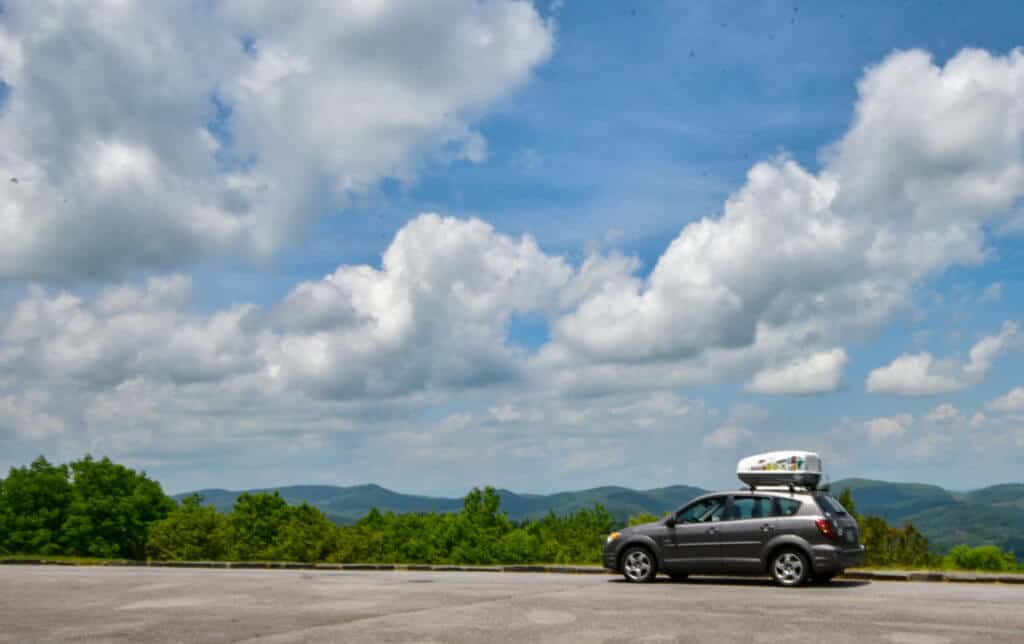 A small grey car parked at an overlook on the Blue Ridge Parkway in Virginia.