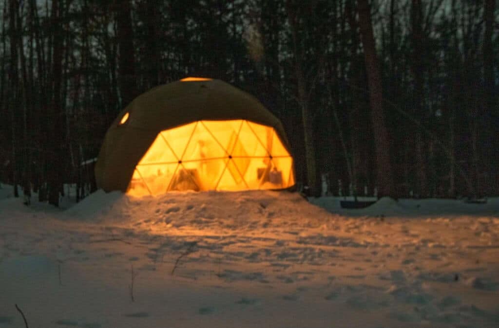 A geodesic dome lit from the inside at night. Putney, Vermont