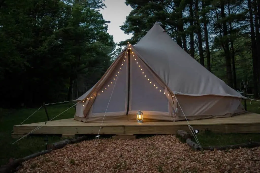 A glamping tent in the evening with fairy lights.