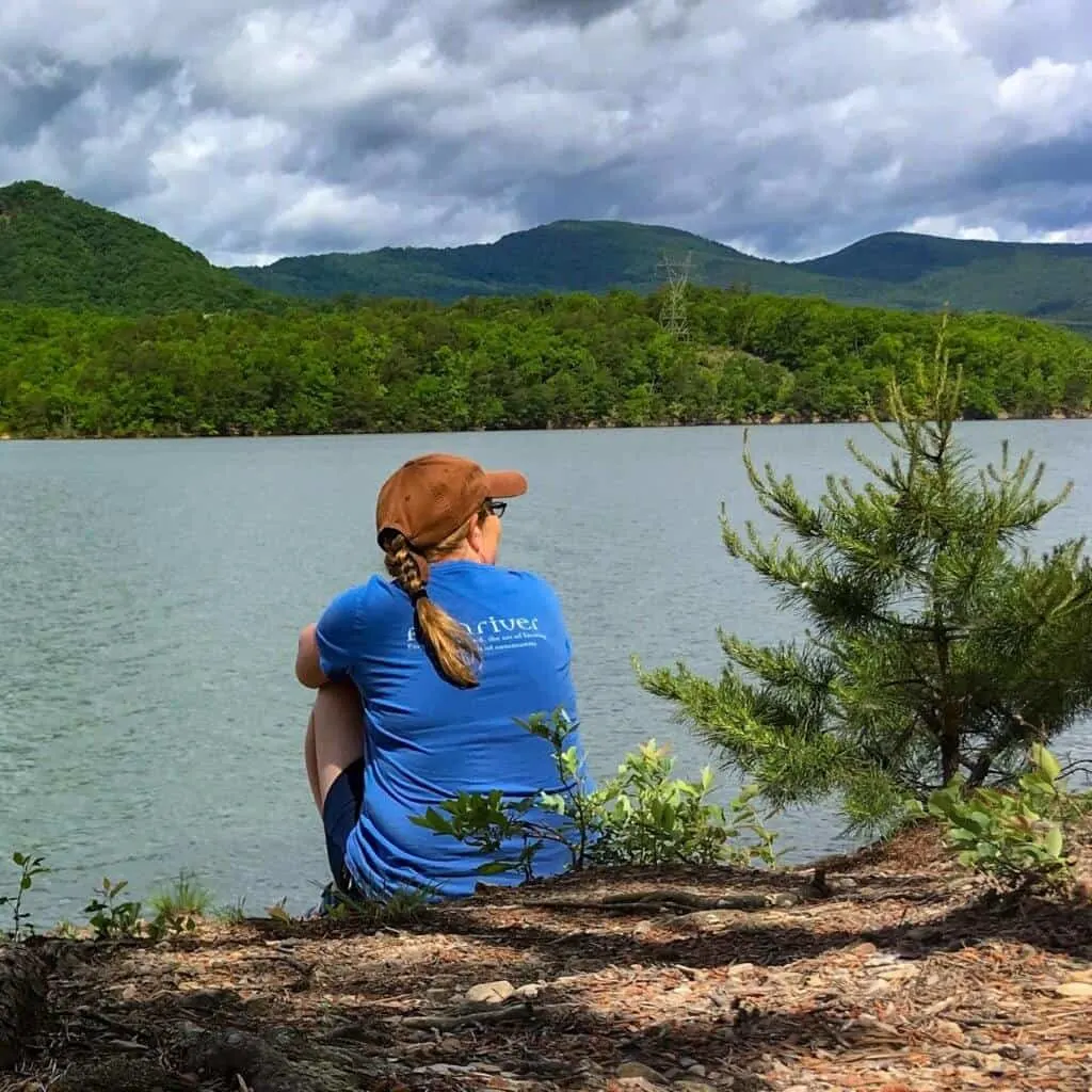 A woman sits by the shore of Carvins Cove Reservoir in Roanoke, Virginia.