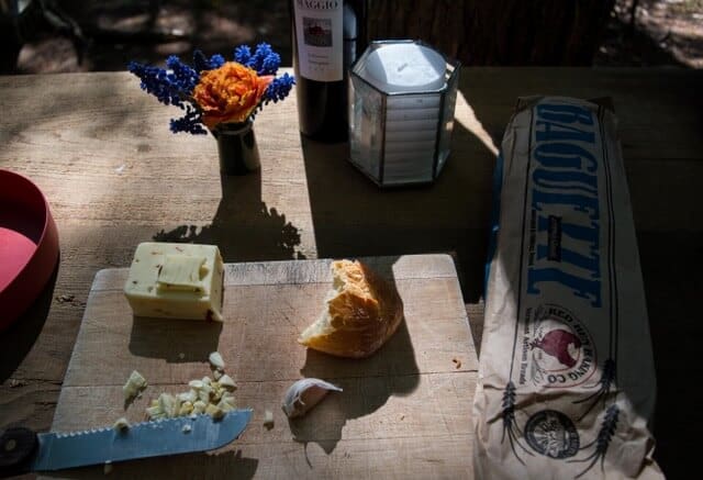 What to pack for a picnic a picnic spread, including bread, cheese, and fresh flowers.