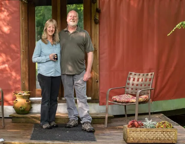 hosts Ellen and Jay standing in front of their yurt rental.