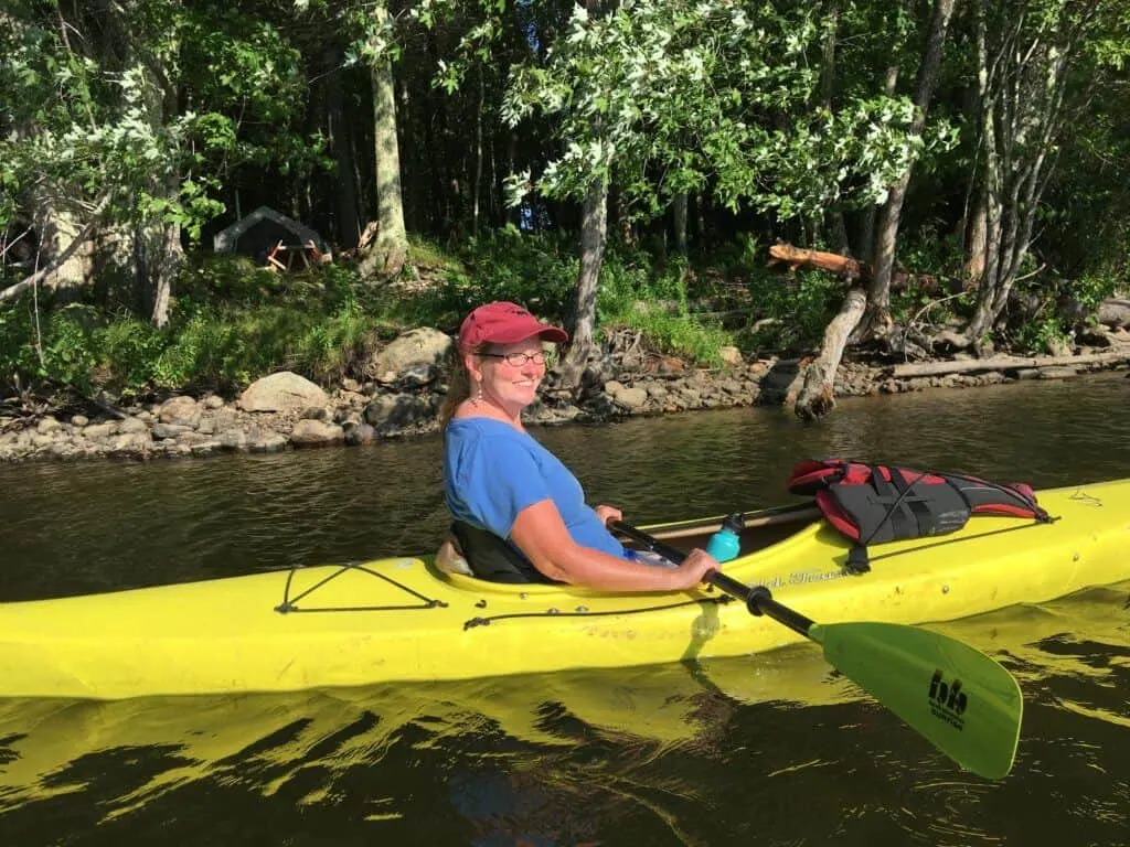 A woman sits in a kayak on the Saco River in Maine.