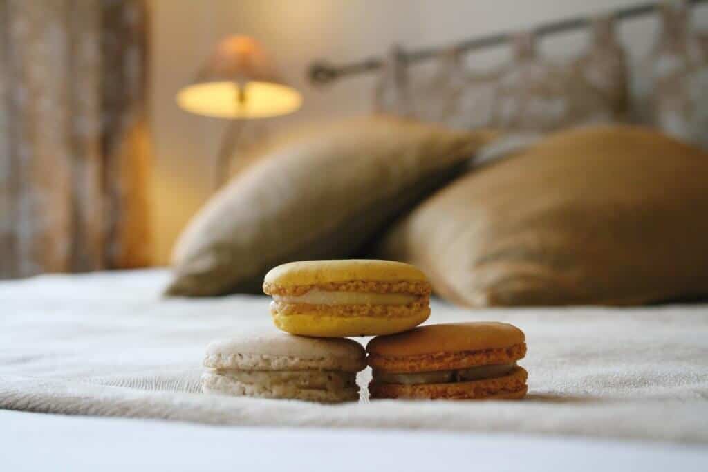 A close-up of macrons stacked on a bed at a small boutique hotel.