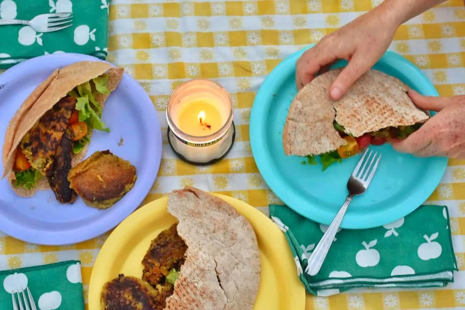 A close up of some camping food on a yellow checked tablecloth.