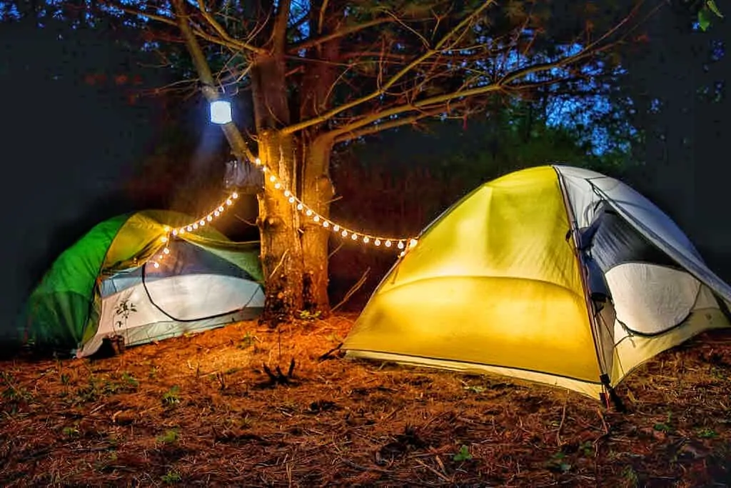 Two tents glowing in the night.