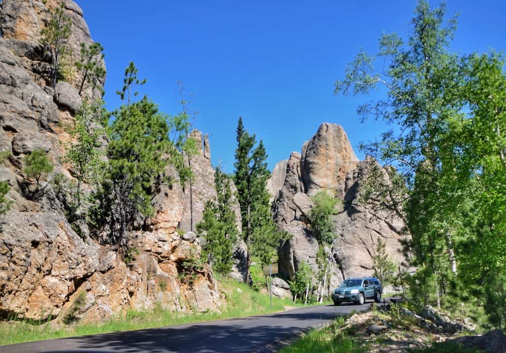 A car drives on the Needles Highway in Custer State Park, South Dakota