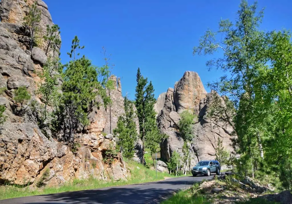 A car drives on the Needles Highway in Custer State Park, South Dakota