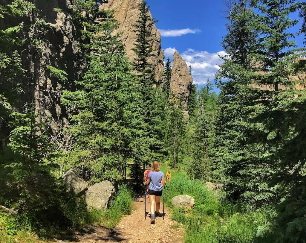 A woman hikes among rock spires on the Sunday Gulch Trail in Custer State Park, South Dakota.