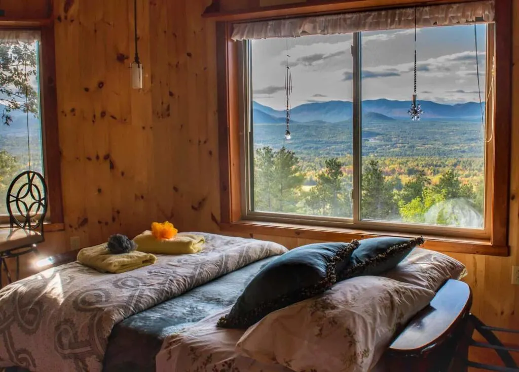 View of the mountains through a window of a cabin in the Adirondacks.