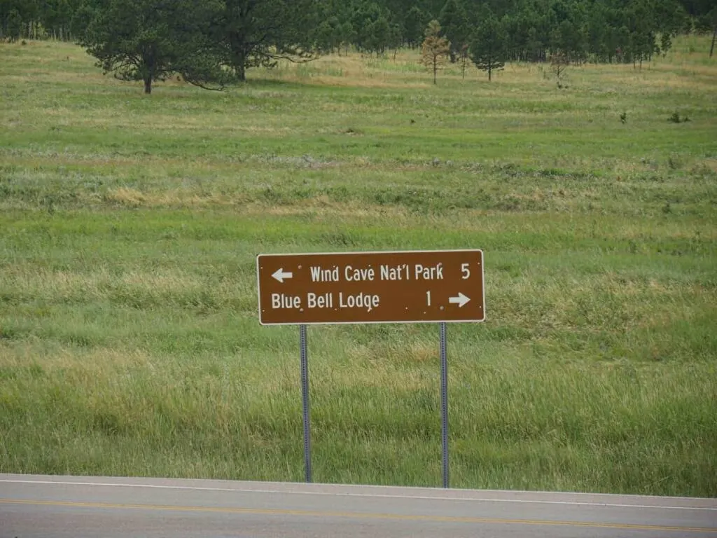 A road sign directing traffic to Blue Bell Lodge or Wind Cave National Park.