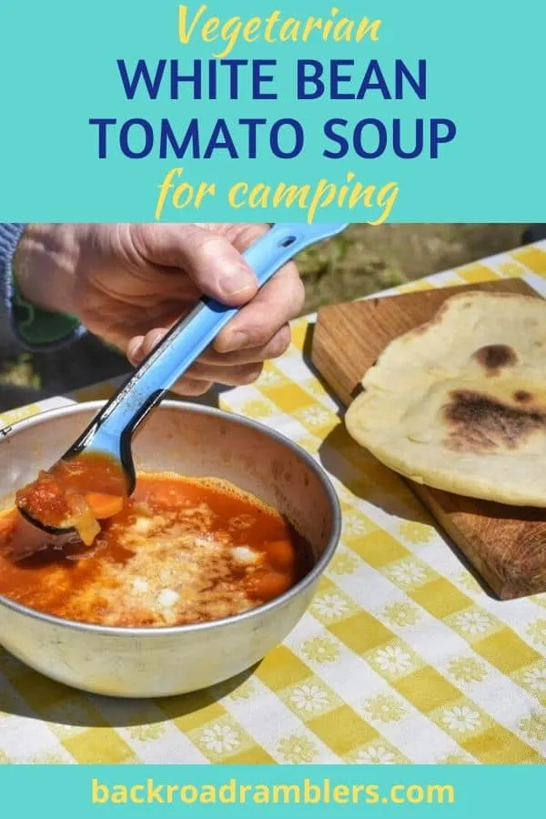 A bowl of vegetarian tomato soup sits on a yellow and white tablecloth.