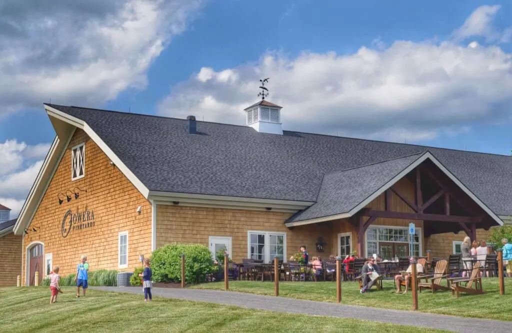 People mingling and kids playing on the lawn in front of Owera Vineyards in Cazenovia, New York.