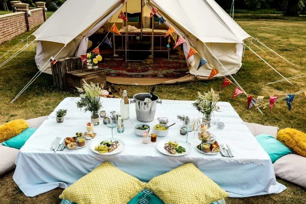 A photo showing a glamping tent with an elaborately set table in front of it.