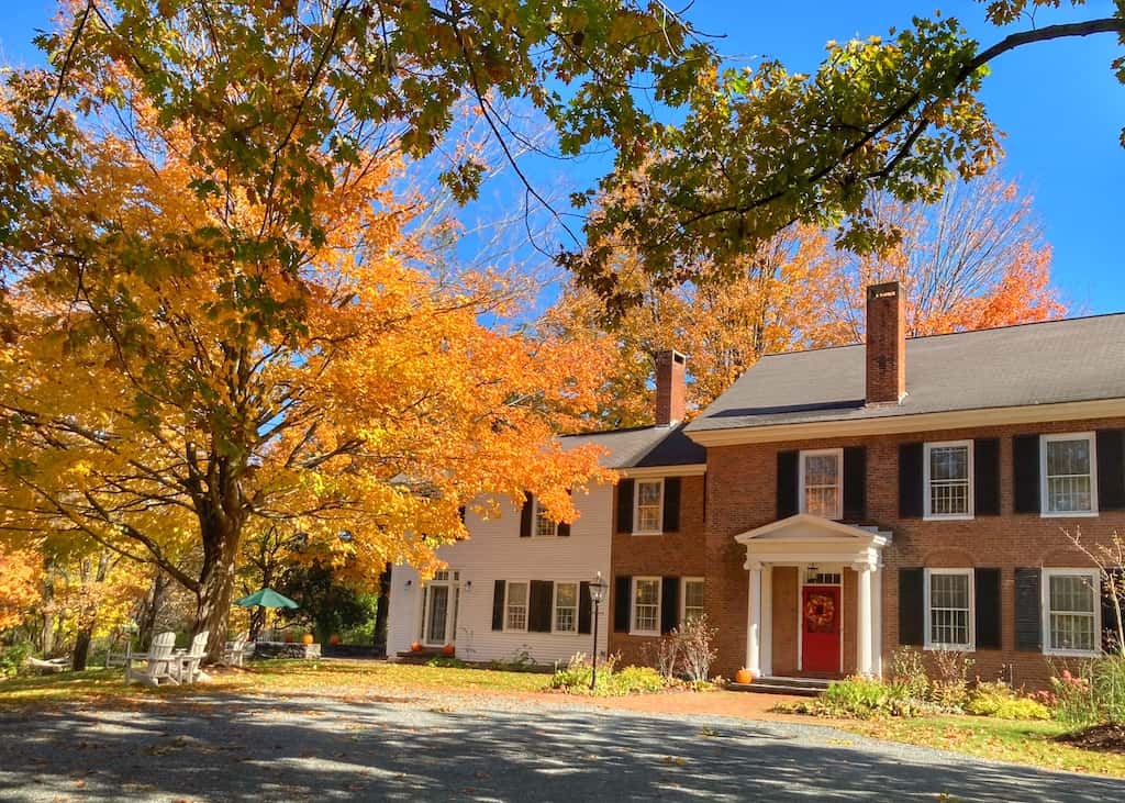 A historic home in downtown Woodstock, Vermont, surrounded by fall foliage