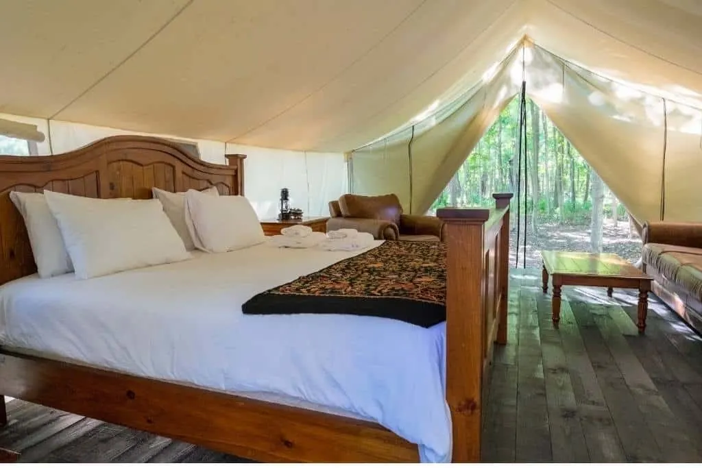 A glamping tent with a large bed in it.