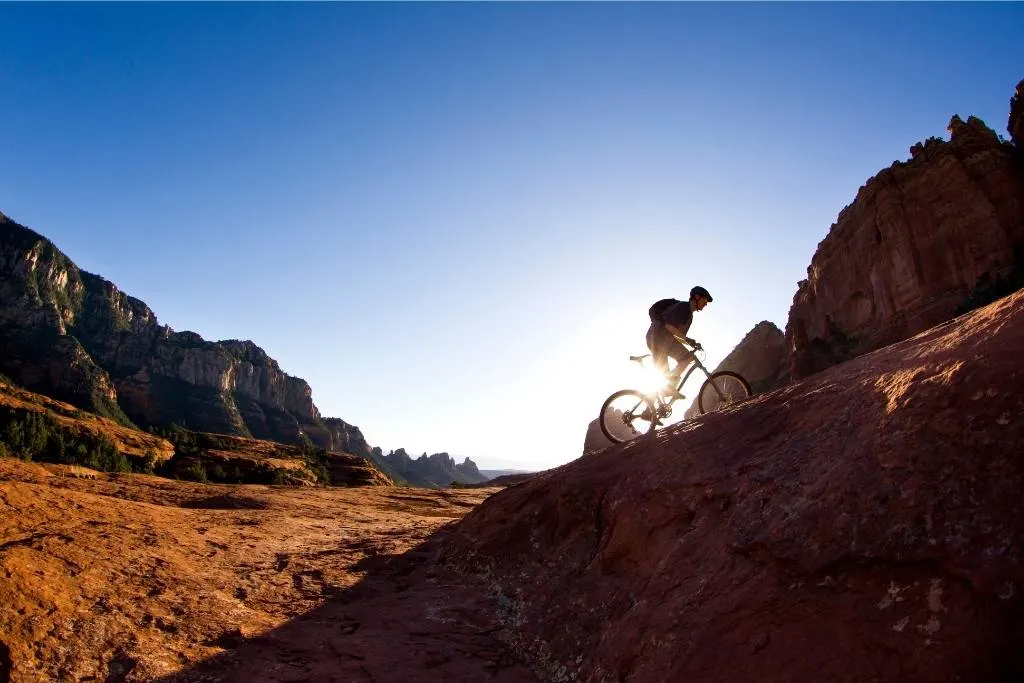 A man mountain bikes in SARA Park in Lake Havasu City, Arizona during the sunset