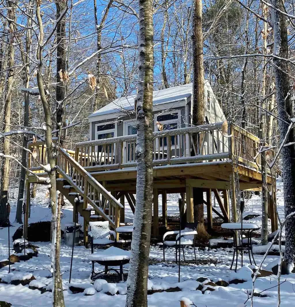 A glamping treehouse in Connecticut surrounded by snowy woods. Photo credit: Airbnb