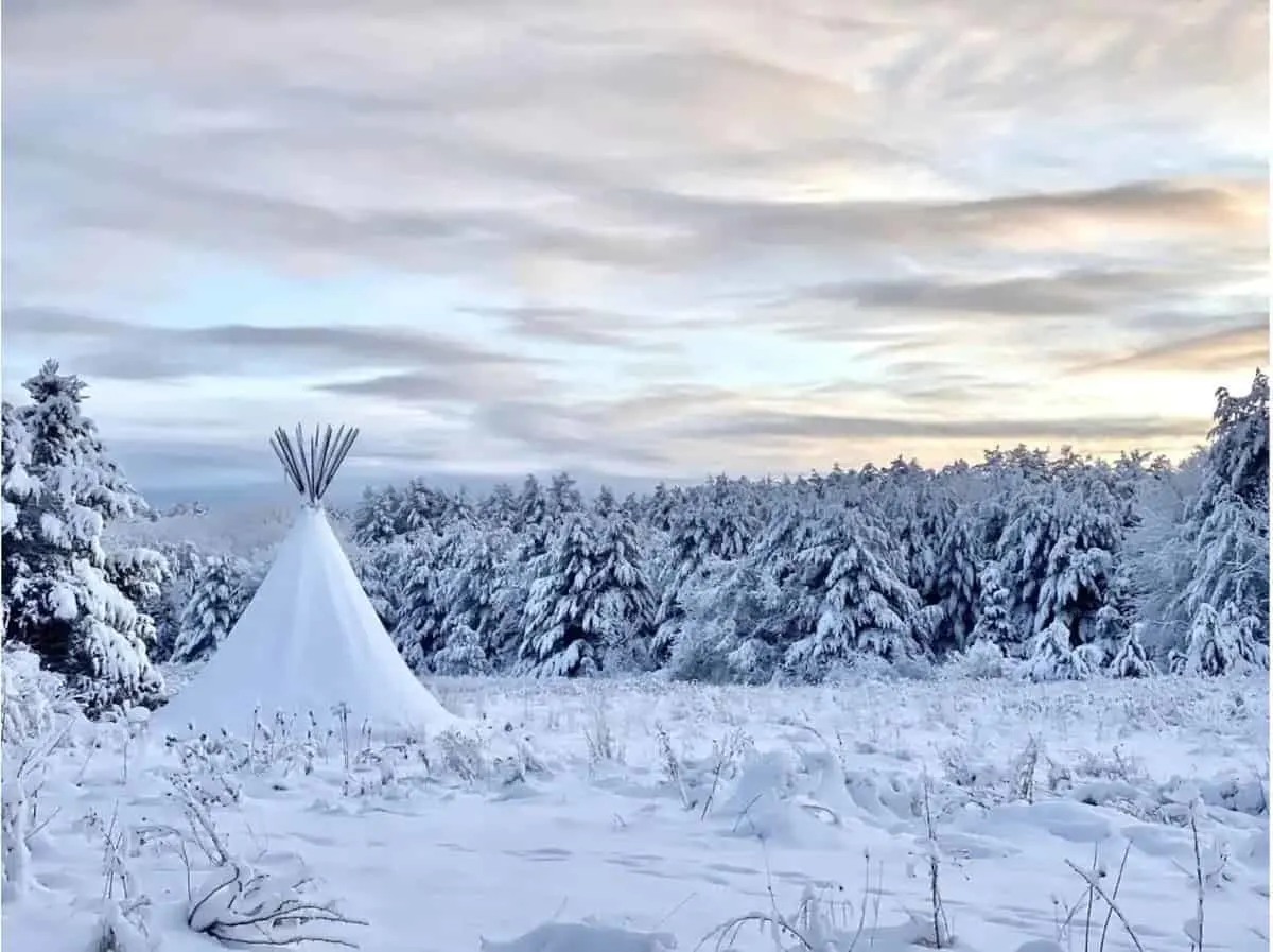 A tipi covered with snow is available to rent for glamping in New York. 