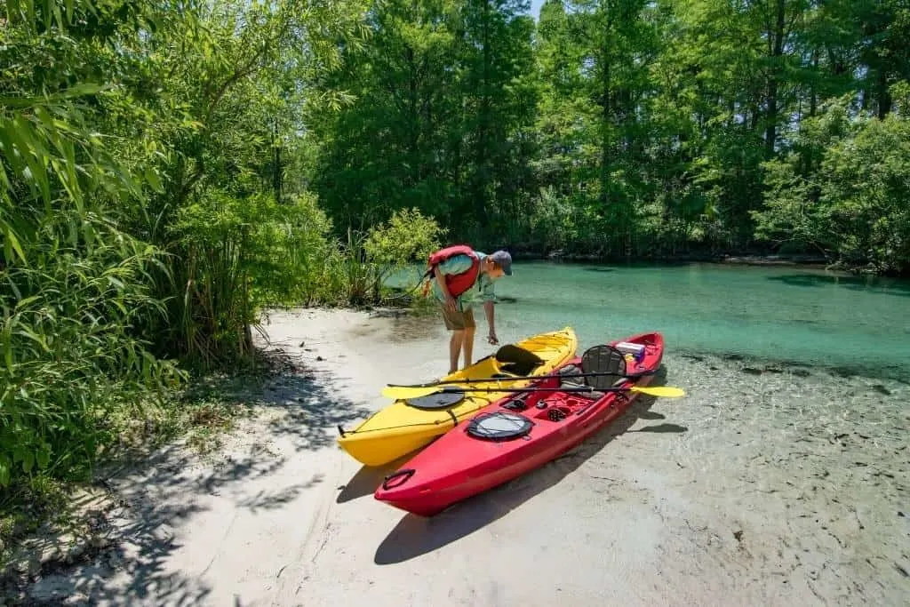 A man hauling a kayak out of the water in Everglades National Park.