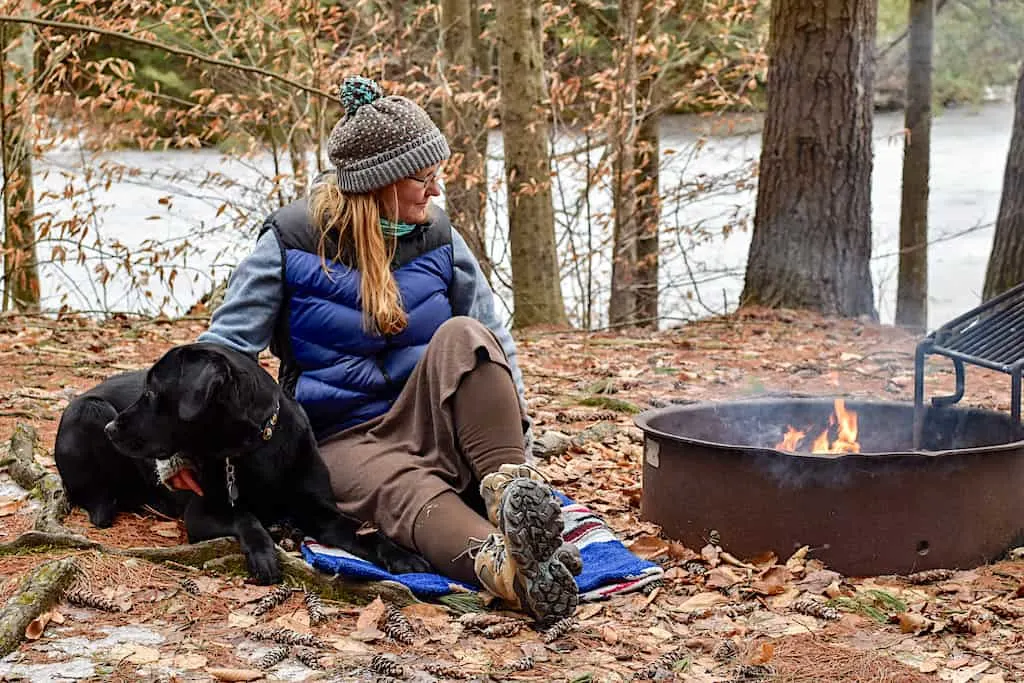 Me, sitting next to a winter campfire with my favorite black lab, Flynn.