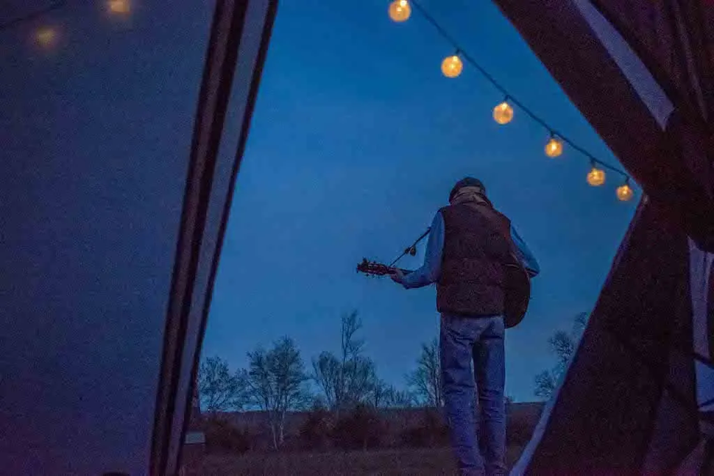 Eric playing the guitar outside our tent.