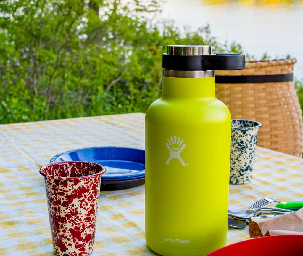 A Hydro Flask growler on a picnic table during a road trip picnic.