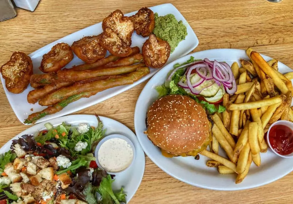 Our lunch at Grit in Caldwell, Idaho - a salad, burger with fries, and tempura asparagus and cauliflower.