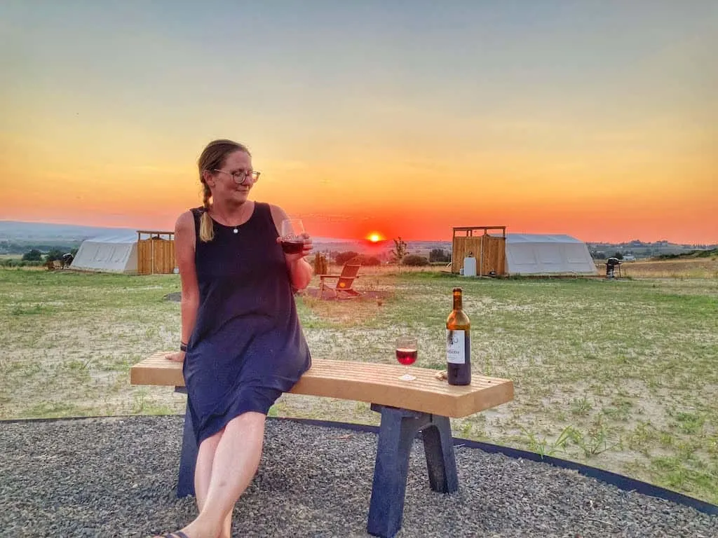 the sun sets behind me as I sip a glass of red wine from Sawtooth Winery in Caldwell, Idaho.