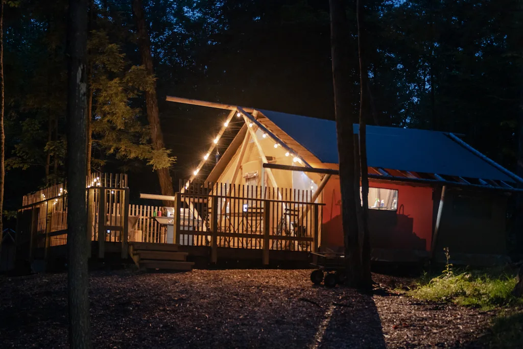 The Trappeur tent at Huttopia Adirondacks at night.