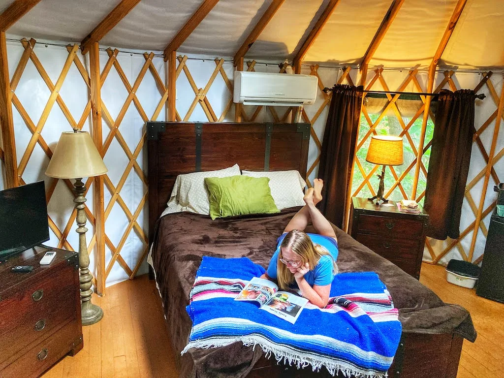 A woman lies on a bed in a yurt at Lake Raystown Resort in Pennsylvania.