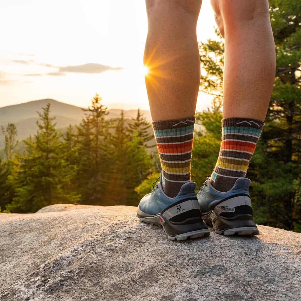 a pair of legs in hiking boots wearing darn tough socks.