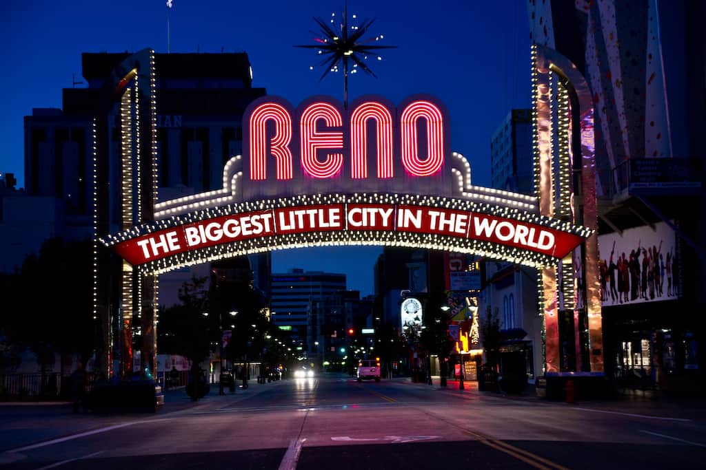 The Reno Arch sign at night says Reno, the Biggest Little City in the World.