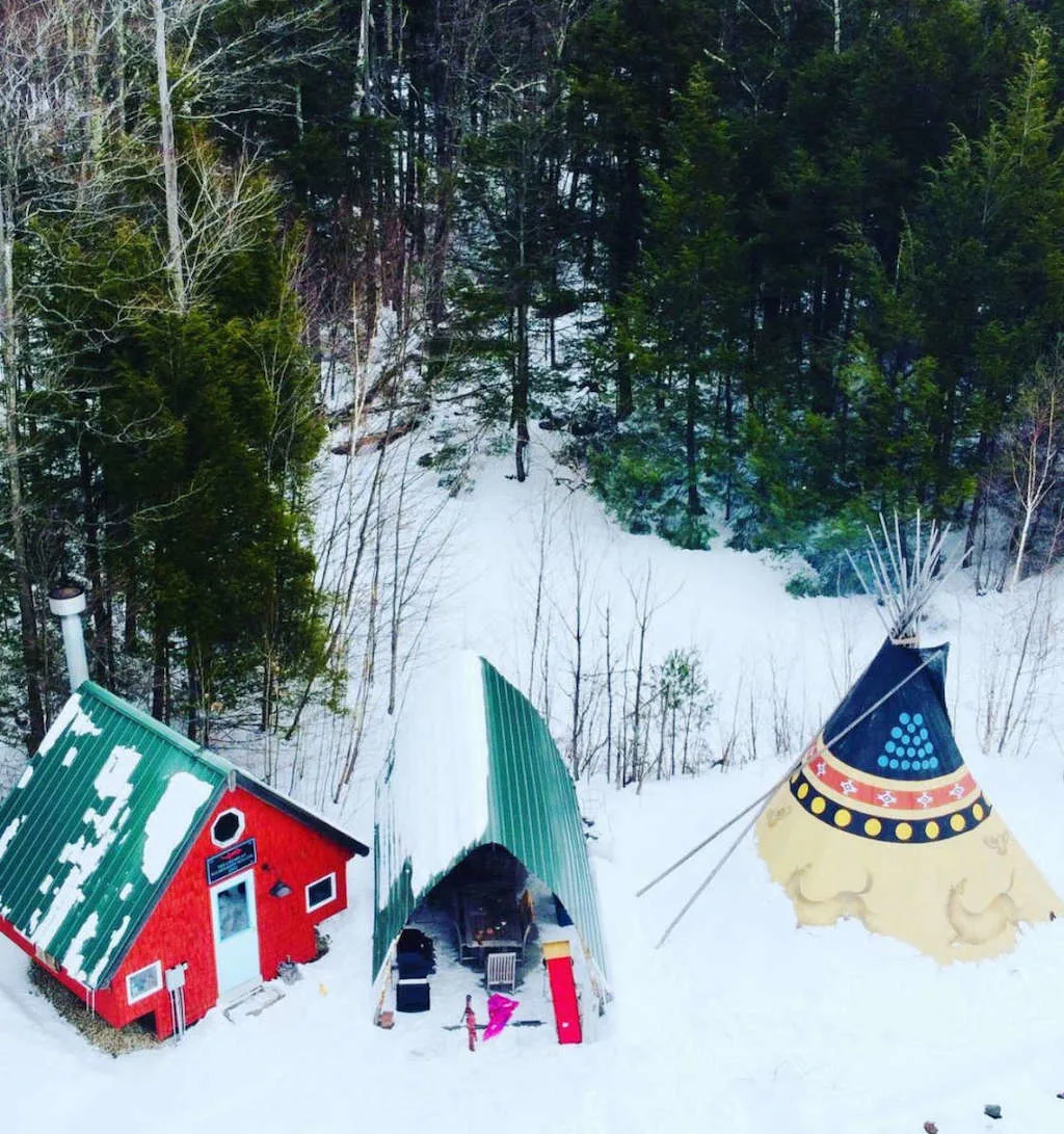 A tipi and glamping cabin in a snowy field in Massachusetts. 