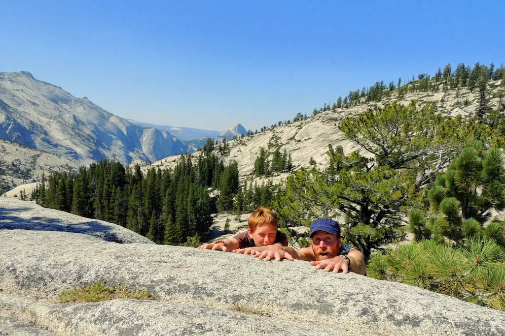 Two people pretending to be rock climbing at Olmstead Point in Yosemite National Park in California.